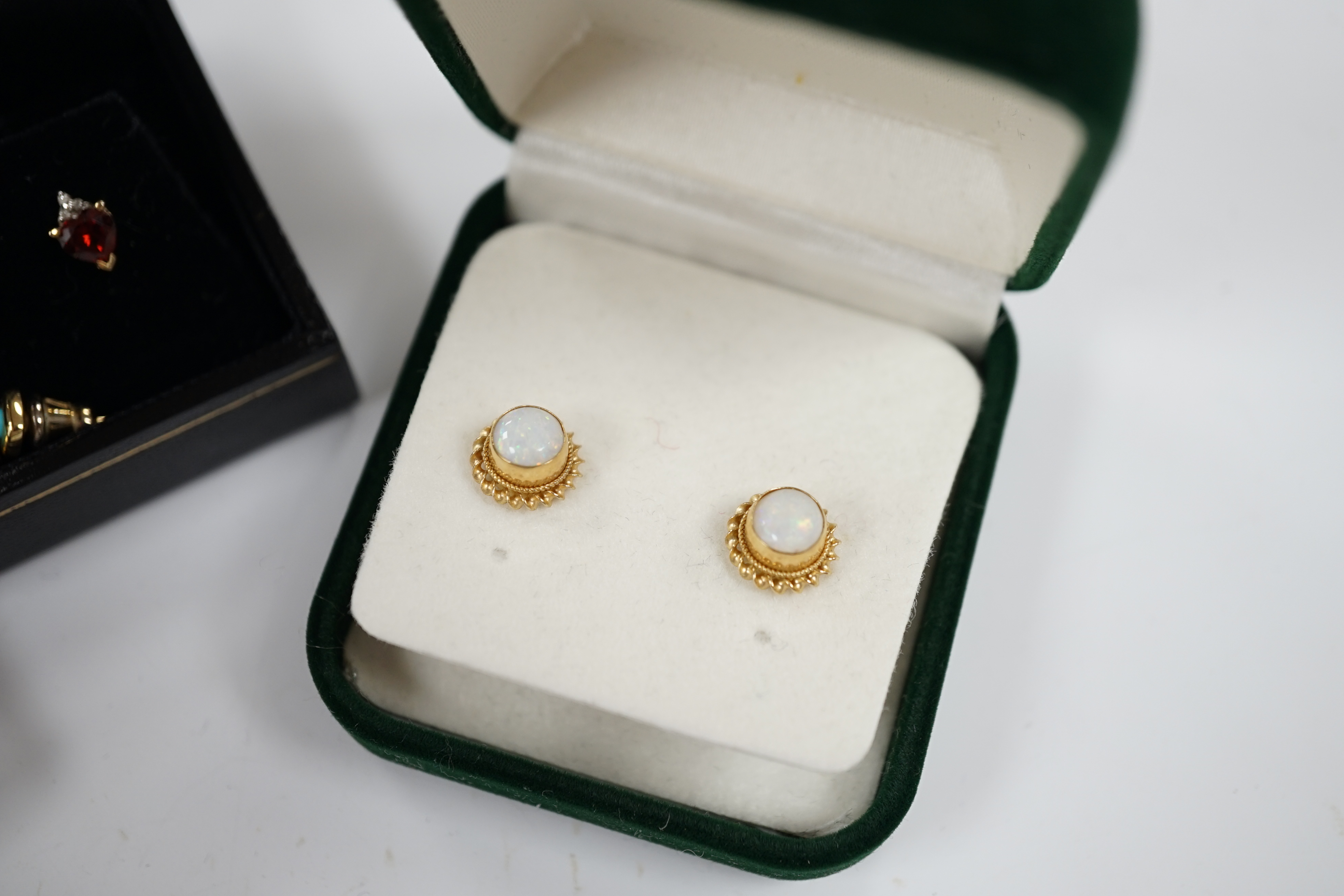 Four assorted pairs of gem set ear studs including 9ct gold and white opal and 9ct gold and garnet.
